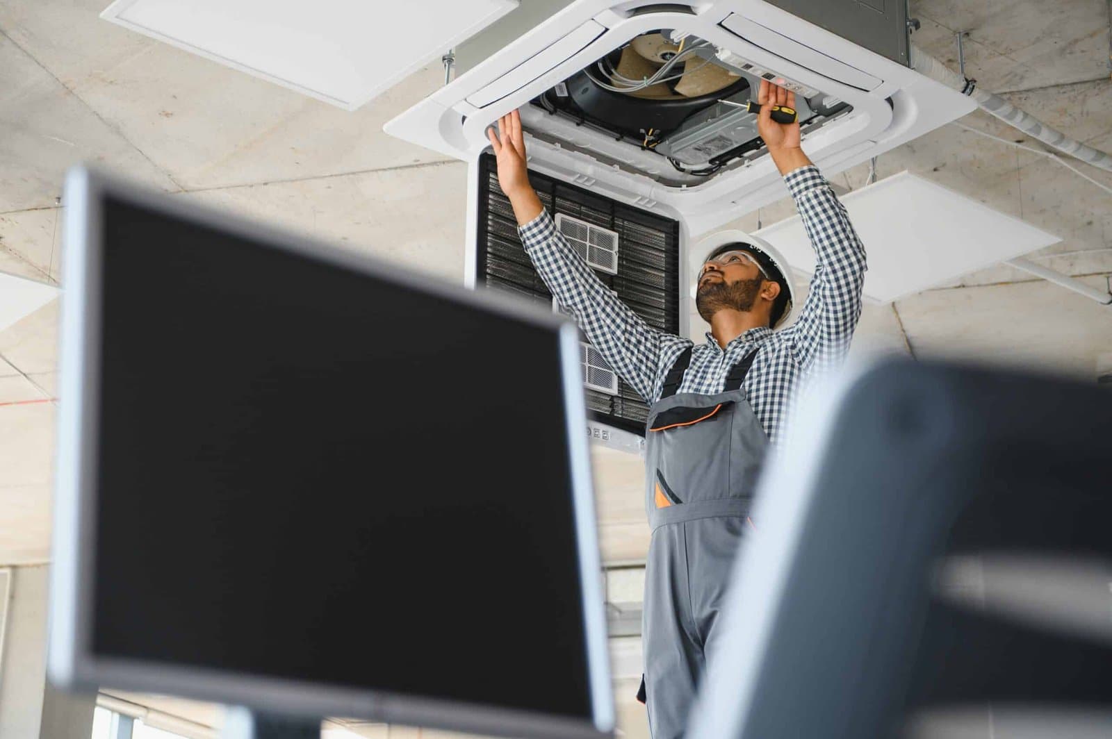 Técnico fazendo a manutenção de um ar-condicionado